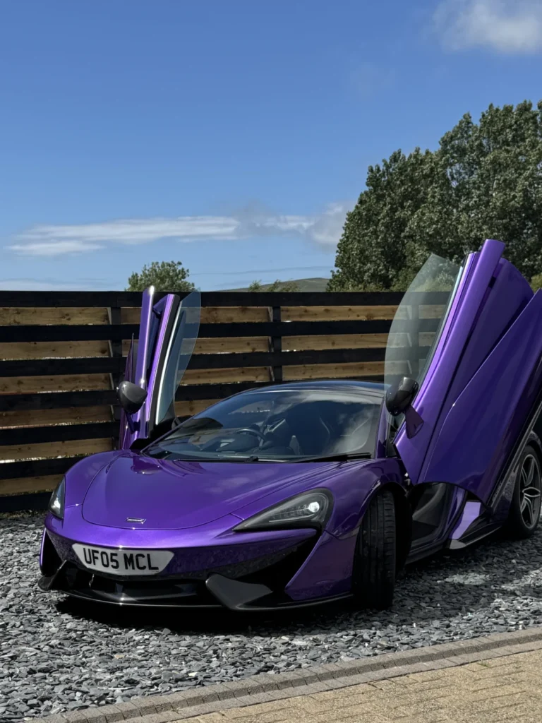 Purple McLaren with its doors up after a detail